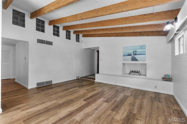 1353 Karen Dr, Cape Girardeau, MO 63701 - unfurnished living room with a brick fireplace, wood finished floors, beam ceiling, baseboards, and brick wall