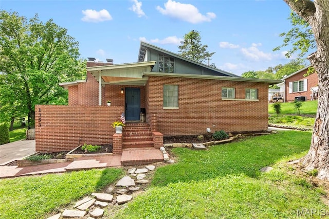 1353 Karen Dr, Cape Girardeau, MO 63701 - rear view of property with entry steps, a lawn, and brick siding