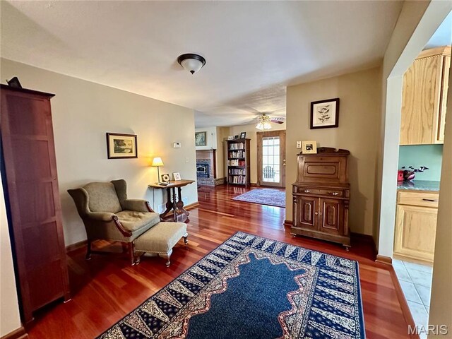 15716 County Road 5190, Rolla, MO 65401 - living area with wood finished floors, ceiling fan, a glass covered fireplace, and baseboards