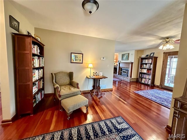 15716 County Road 5190, Rolla, MO 65401 - sitting room featuring a fireplace, wood finished floors, a ceiling fan, and baseboards