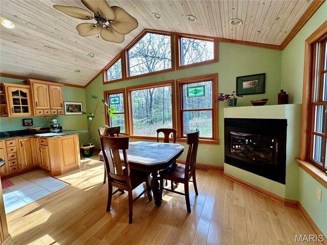 15716 County Road 5190, Rolla, MO 65401 - dining area featuring wooden ceiling, plenty of natural light, a glass covered fireplace, light wood-style flooring, and baseboards