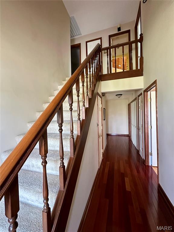 15716 County Road 5190, Rolla, MO 65401 - stairway with wood finished floors, baseboards, and a towering ceiling