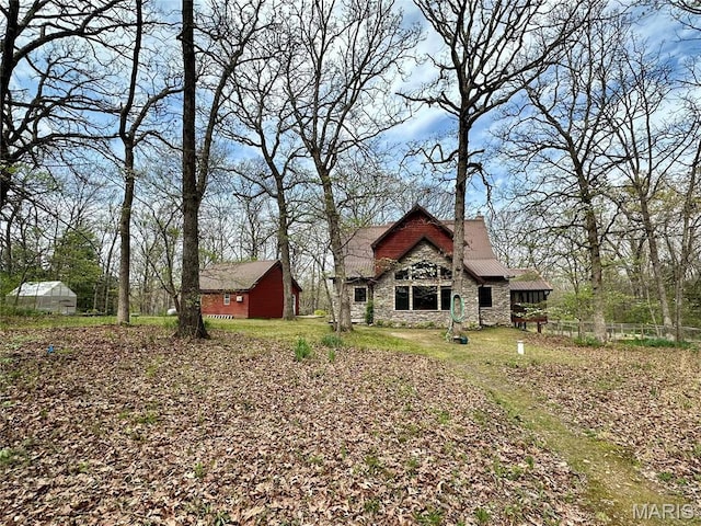 15716 County Road 5190, Rolla, MO 65401 - back of house featuring stone siding, an outbuilding, an exterior structure, and fence