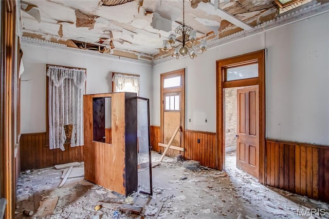 212 Franklin St, Hardin, IL 62047 - empty room featuring a wainscoted wall, wooden walls, and a chandelier