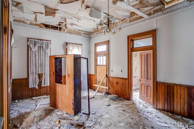 212 Franklin St, Hardin, IL 62047 - spare room featuring a wainscoted wall, wood walls, and a chandelier