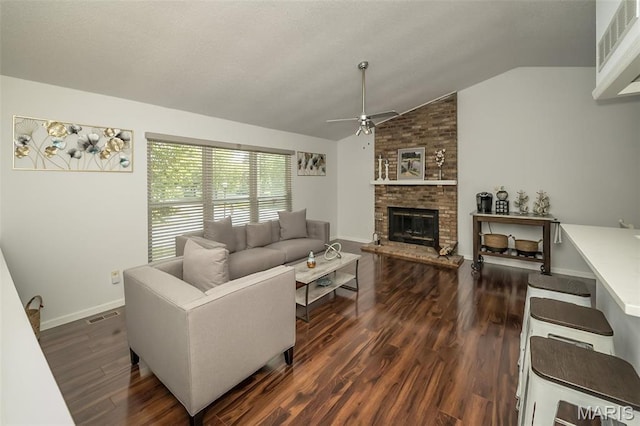 101 Holly Green Dr, Ballwin, MO 63021 - living area with a ceiling fan, vaulted ceiling, dark wood-style flooring, a brick fireplace, and baseboards