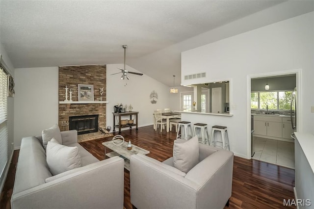 101 Holly Green Dr, Ballwin, MO 63021 - living area with ceiling fan, lofted ceiling, wood finished floors, a brick fireplace, and baseboards