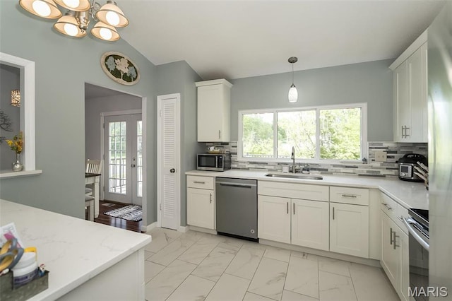 101 Holly Green Dr, Ballwin, MO 63021 - kitchen with a sink, appliances with stainless steel finishes, light marble finish flooring, plenty of natural light, and lofted ceiling