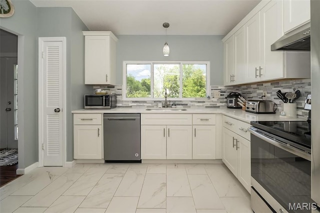 101 Holly Green Dr, Ballwin, MO 63021 - kitchen with stainless steel appliances, under cabinet range hood, a sink, light marble finish floors, and light countertops