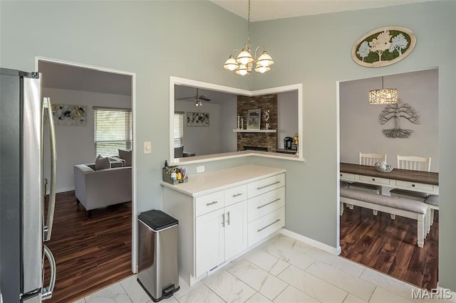 101 Holly Green Dr, Ballwin, MO 63021 - kitchen with freestanding refrigerator, a chandelier, light countertops, light marble finish floors, and high vaulted ceiling