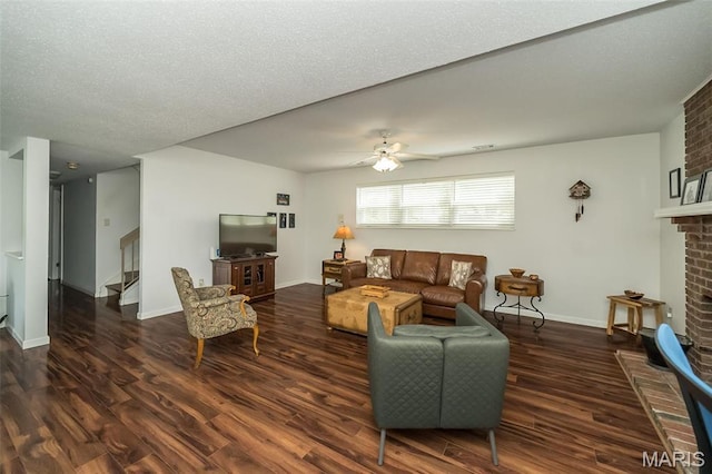 101 Holly Green Dr, Ballwin, MO 63021 - living room with wood finished floors, a ceiling fan, stairway, a brick fireplace, and a textured ceiling