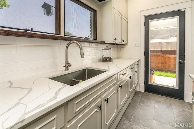 305 W Ray St, Christopher, IL 62822 - kitchen featuring a sink, light marble finish flooring, decorative backsplash, and light stone counters