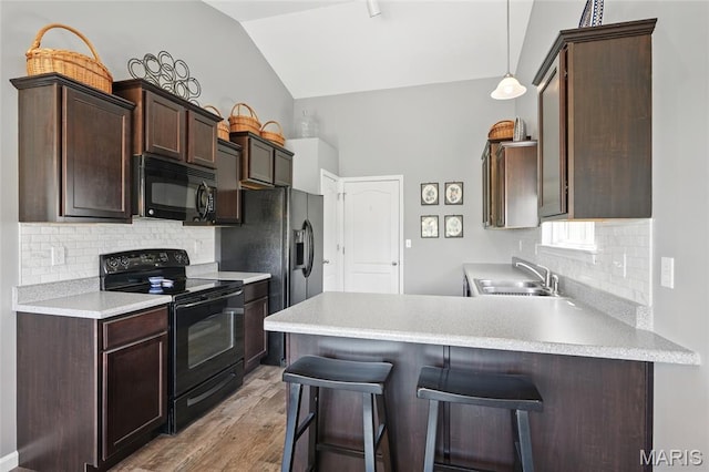 71 Hidden Mill Ct, Moscow Mills, MO 63362 - kitchen featuring black appliances, lofted ceiling, a sink, a peninsula, and dark brown cabinets