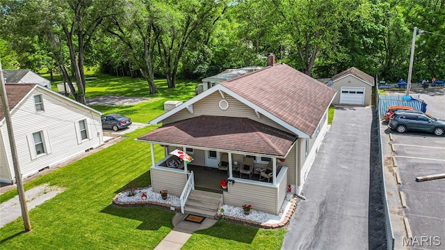 106 E Ofallon Dr, Caseyville, IL 62232 - view of front of house with covered porch, a front yard, roof with shingles, and view of scattered trees