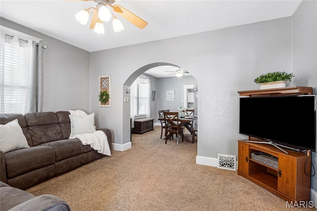 106 E Ofallon Dr, Caseyville, IL 62232 - living area with arched walkways, ceiling fan, light colored carpet, and baseboards