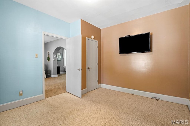 106 E Ofallon Dr, Caseyville, IL 62232 - unfurnished bedroom with carpet flooring, arched walkways, and baseboards