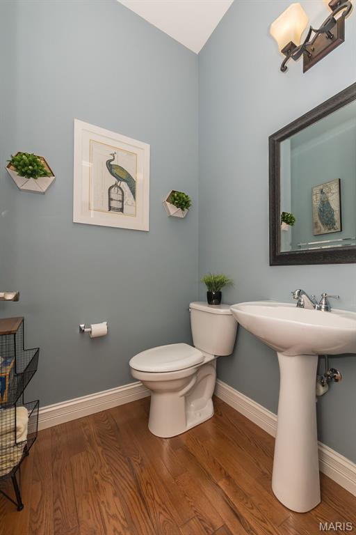1804 Sterling Oaks Dr, Saint Peters, MO 63376 - half bath with toilet, wood finished floors, baseboards, and vaulted ceiling