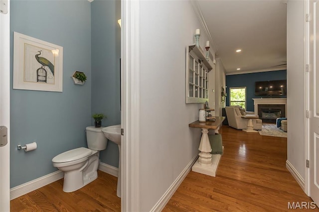 1804 Sterling Oaks Dr, Saint Peters, MO 63376 - bathroom with ornamental molding, toilet, wood finished floors, a glass covered fireplace, and baseboards