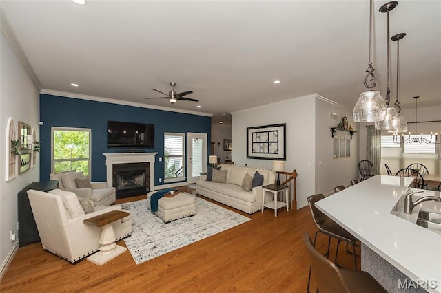 1804 Sterling Oaks Dr, Saint Peters, MO 63376 - living area featuring wood finished floors, crown molding, a ceiling fan, a fireplace, and recessed lighting