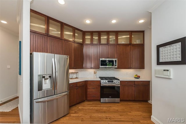 1804 Sterling Oaks Dr, Saint Peters, MO 63376 - kitchen with stainless steel appliances, light countertops, light wood-type flooring, baseboards, and crown molding