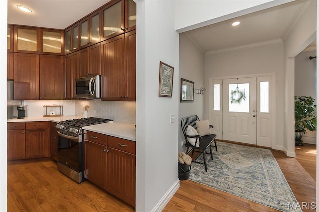 1804 Sterling Oaks Dr, Saint Peters, MO 63376 - kitchen featuring appliances with stainless steel finishes, light countertops, baseboards, wood finished floors, and crown molding