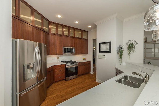 1804 Sterling Oaks Dr, Saint Peters, MO 63376 - kitchen featuring appliances with stainless steel finishes, a sink, crown molding, wood finished floors, and light countertops