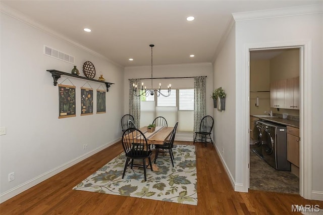 1804 Sterling Oaks Dr, Saint Peters, MO 63376 - dining space featuring washer / clothes dryer, ornamental molding, a chandelier, dark wood finished floors, and baseboards