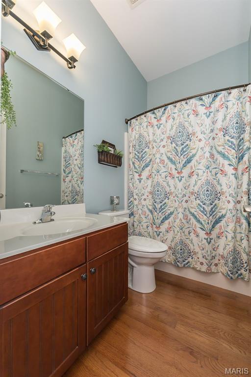 1804 Sterling Oaks Dr, Saint Peters, MO 63376 - full bathroom with wood finished floors, toilet, vanity, and a shower with shower curtain