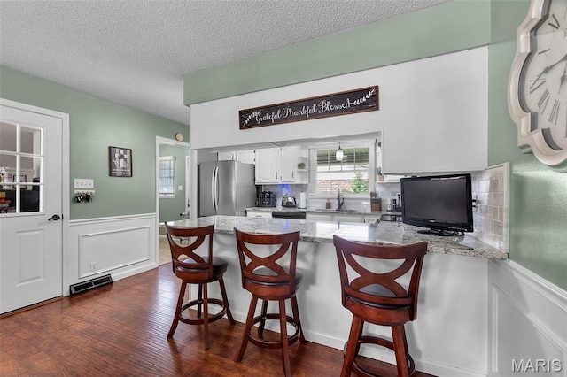 729 Euclid Dr, Sikeston, MO 63801 - kitchen featuring freestanding refrigerator, a sink, dark wood-style floors, a textured ceiling, and a peninsula