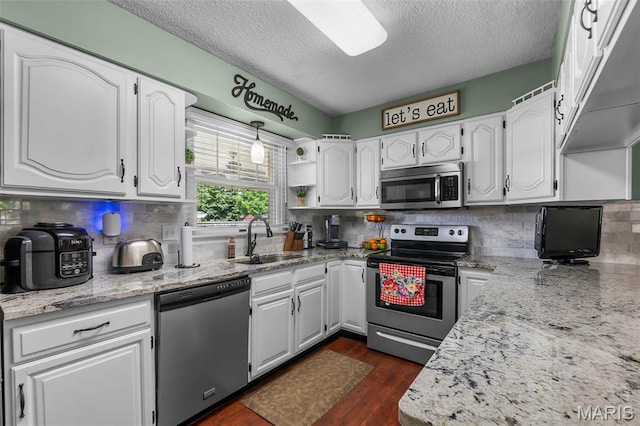 729 Euclid Dr, Sikeston, MO 63801 - kitchen featuring stainless steel appliances, a textured ceiling, a sink, white cabinetry, and backsplash