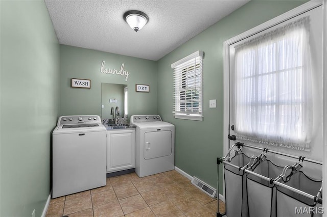 729 Euclid Dr, Sikeston, MO 63801 - laundry room with cabinet space, washer and clothes dryer, a textured ceiling, baseboards, and light tile patterned floors