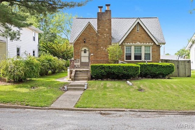 tudor-style house with brick siding and a chimney