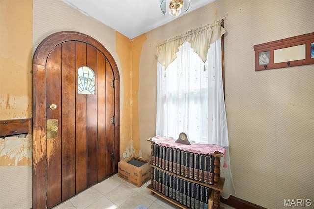 entrance foyer with light tile patterned floors and arched walkways