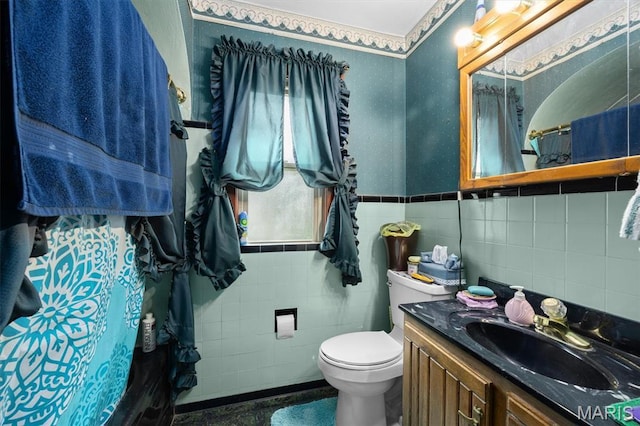 bathroom featuring tile walls, toilet, a wainscoted wall, and vanity