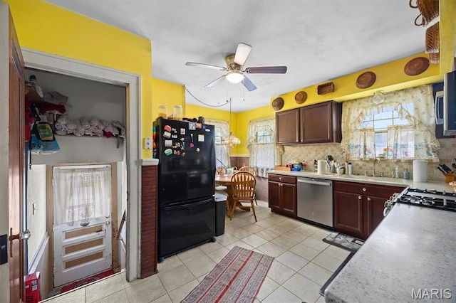 kitchen featuring appliances with stainless steel finishes, a sink, a ceiling fan, light tile patterned floors, and light countertops