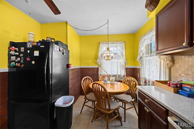 dining area with wainscoting, a ceiling fan, and light tile patterned floors