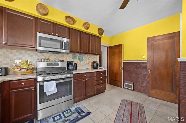 kitchen featuring stainless steel appliances, light countertops, tasteful backsplash, and light tile patterned floors
