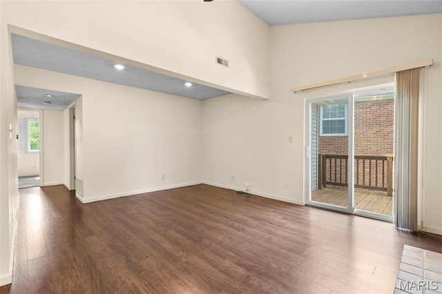 unfurnished room featuring dark wood-type flooring, baseboards, and recessed lighting