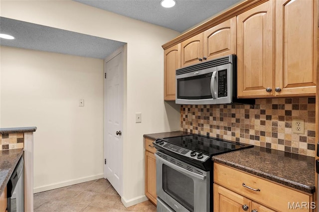 kitchen with stainless steel appliances, tasteful backsplash, baseboards, dark stone counters, and light brown cabinets