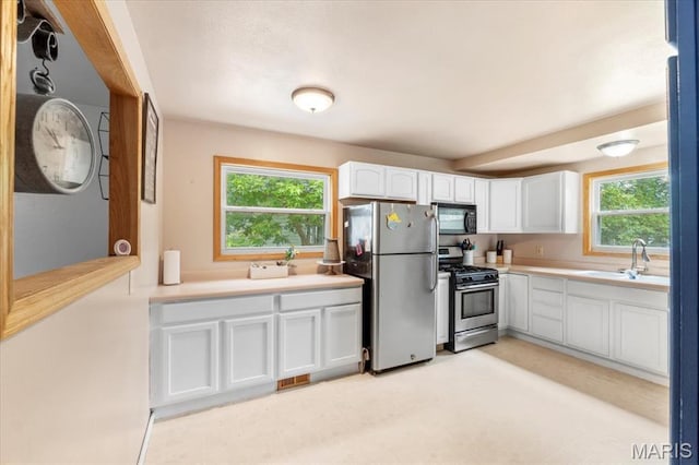 2270 Grants Pkwy, Florissant, MO 63031 - kitchen with stainless steel appliances, a sink, white cabinetry, and plenty of natural light