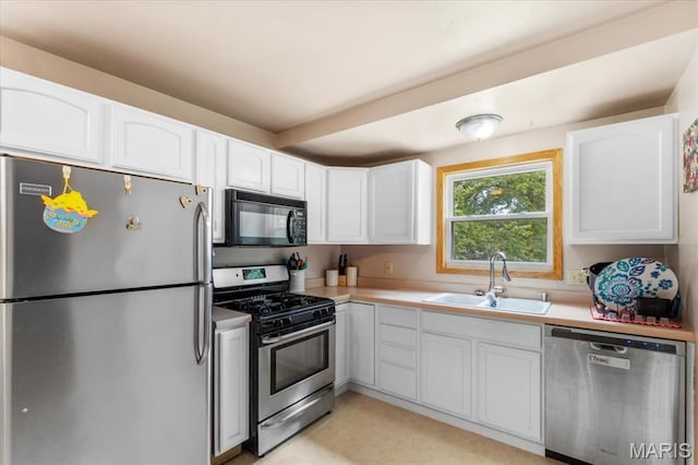 2270 Grants Pkwy, Florissant, MO 63031 - kitchen with stainless steel appliances, a sink, white cabinets, and light countertops
