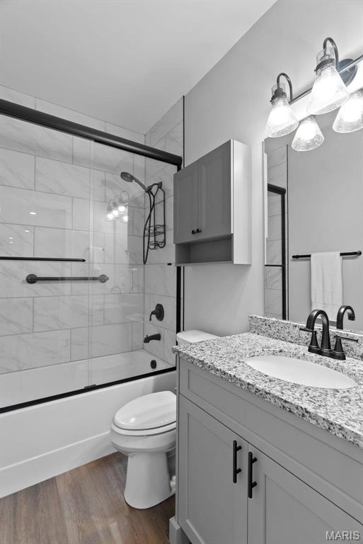 25 Gregory Michael Ln, Wright City, MO 63390 - bathroom with vanity, toilet, shower / bath combination with glass door, and wood finished floors