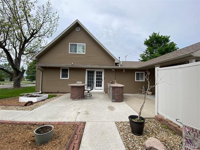 back of property featuring a patio and fence