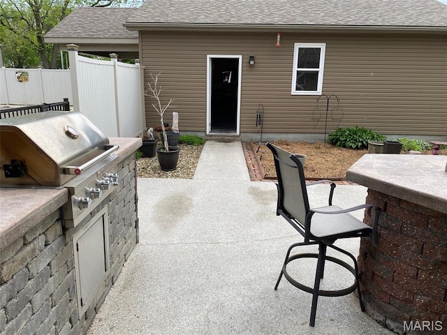view of patio featuring area for grilling and fence