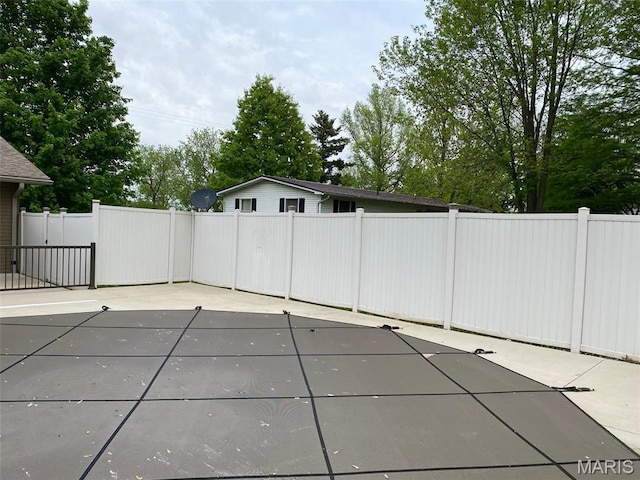 view of swimming pool featuring fence and a patio area
