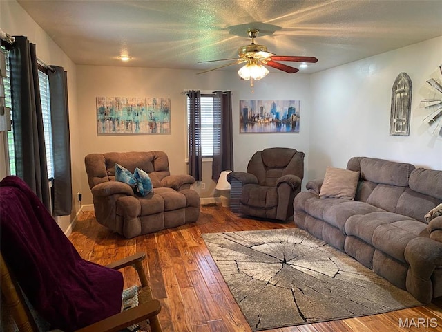 living area featuring a ceiling fan, wood finished floors, and baseboards