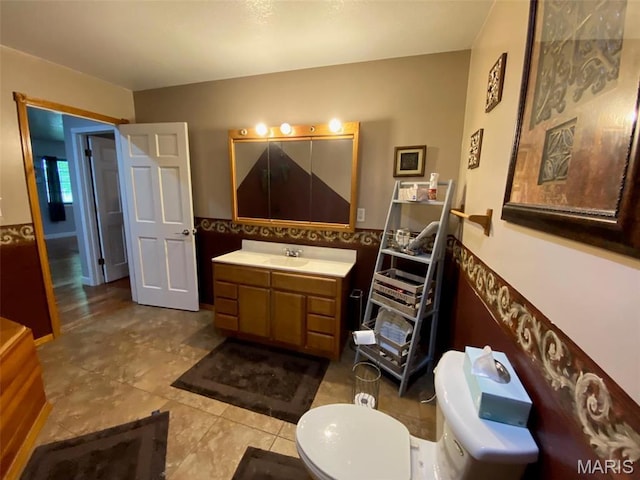 bathroom featuring toilet, vanity, and tile patterned flooring