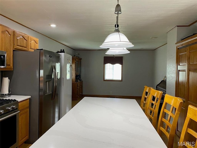 kitchen featuring appliances with stainless steel finishes, decorative light fixtures, and brown cabinetry