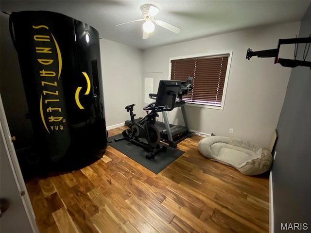 exercise area featuring ceiling fan, wood finished floors, and baseboards