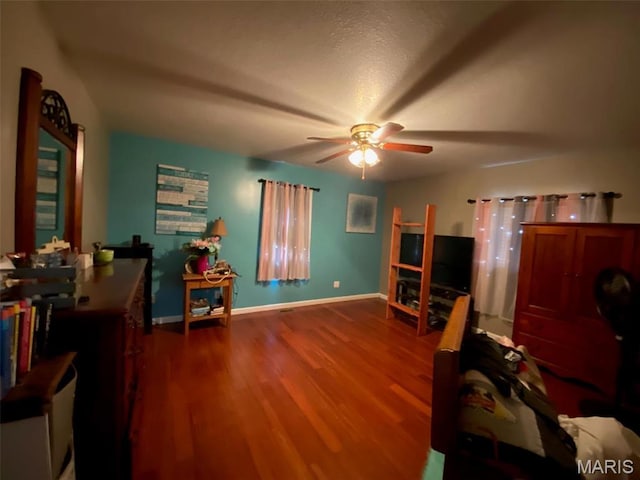 interior space with ceiling fan, wood finished floors, and baseboards
